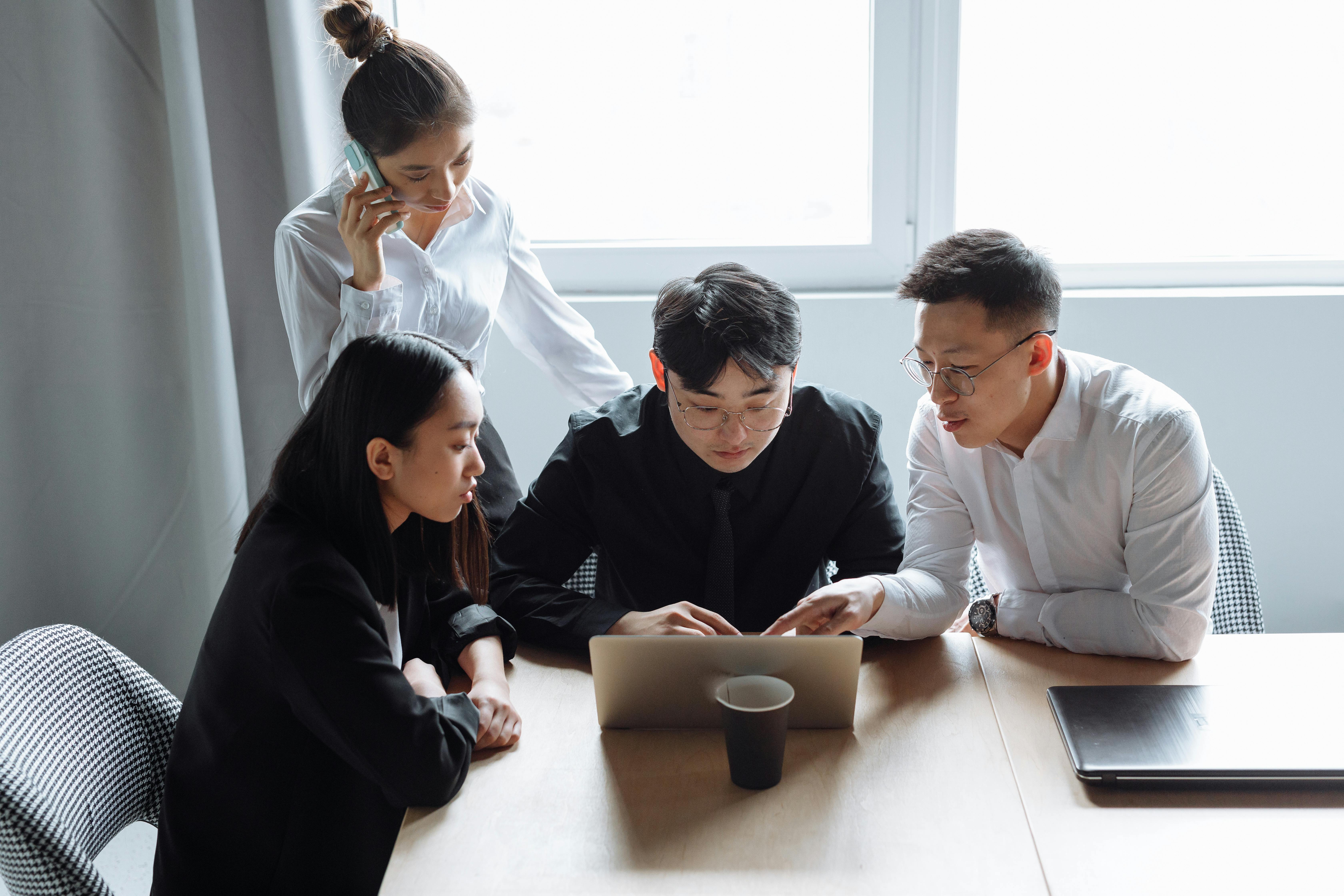 Operations team collaborating around a laptop